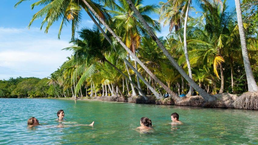 Friends vacationing enjoying the tranquil waters at Boca del Drago in Bocas del Toro