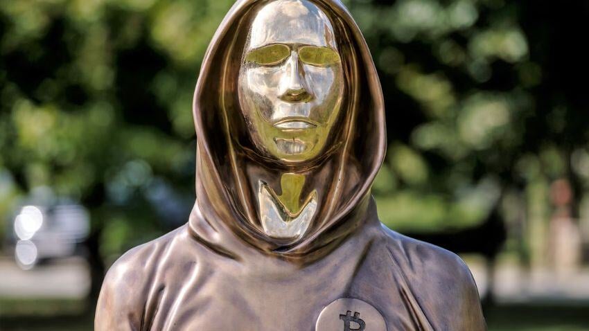 The bronze statue of Satoshi Nakamoto in Budapest honours the anonymous creator of Bitcoin, with a mirrored face symbolizing that "we are all Satoshi," reflecting the decentralization and community behind cryptocurrencies